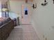 Foyer with white tiled floor and white door with stain glass, wall sconces, and view of living room at 209 Silas Phelps W Ct, Orlando, FL 32828