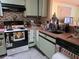 Kitchen area with pink countertops, electric stovetop, tiled backsplash, and black and green cabinets at 209 Silas Phelps W Ct, Orlando, FL 32828