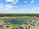 Aerial view of a neighborhood with a central lake, playground, and well-maintained lawns and landscaping at 3348 Perennial Ln, Kissimmee, FL 34746