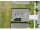 Aerial view of a home featuring solar panels, a new roof and a well-kept lawn at 3348 Perennial Ln, Kissimmee, FL 34746