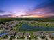 Wide aerial view of a residential neighborhood with homes surrounding a lake and green spaces at 3348 Perennial Ln, Kissimmee, FL 34746