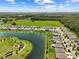 Sprawling aerial view of a neighborhood with a lake, community park, and well-maintained lawns at 3348 Perennial Ln, Kissimmee, FL 34746