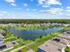 Beautiful aerial of a community with homes surrounding a lake with green common areas and mature trees at 3348 Perennial Ln, Kissimmee, FL 34746