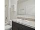 Bathroom with a dark vanity and a shower-tub combo at 3348 Perennial Ln, Kissimmee, FL 34746