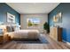 Serene bedroom with calming blue walls, a comfortable bed, and a picturesque view of the outdoors at 3348 Perennial Ln, Kissimmee, FL 34746