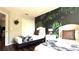 Comfortable bedroom featuring two twin beds, tropical wallpaper accent wall, and white nightstand at 339 Sigmund Loop, Davenport, FL 33837