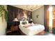 Cozy bedroom features an elegant bed, lamps, forest mural, and decorative chandelier at 339 Sigmund Loop, Davenport, FL 33837