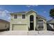 Charming two-story home featuring an arched entryway and an attached two-car garage at 339 Sigmund Loop, Davenport, FL 33837