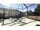 The covered patio area has a dining table, chairs, and grill with a view of the back yard at 339 Sigmund Loop, Davenport, FL 33837