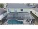 View of a home's backyard featuring a screened-in pool, patio, and lush landscaping at 339 Sigmund Loop, Davenport, FL 33837