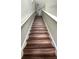 Interior view of wood-look stairs going up, flanked by light gray walls and white railing at 339 Sigmund Loop, Davenport, FL 33837