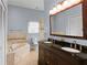 Bathroom featuring double sinks, granite countertops, and a soaking tub at 4353 Steed Ter, Winter Park, FL 32792