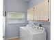 Functional laundry room with a washer, dryer, and upper cabinets for storage at 4353 Steed Ter, Winter Park, FL 32792