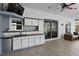 Outdoor kitchen with built-in cabinets, sink, mini fridge, and ceiling fan at 4353 Steed Ter, Winter Park, FL 32792