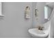Elegant half-bathroom featuring a wall-mounted round mirror, a stylish faucet, and classic decor at 8340 Laureate Blvd, Orlando, FL 32827