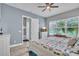 Bright bedroom featuring a TV, a large window, and a dresser with an open doorway at 8340 Laureate Blvd, Orlando, FL 32827