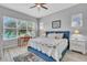 Serene bedroom with a blue upholstered bed, a sunny window view, and decorative lamps on white nightstands at 8340 Laureate Blvd, Orlando, FL 32827