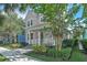 Charming two-story home with a cozy front porch, lush landscaping, and inviting curb appeal on a sunny day at 8340 Laureate Blvd, Orlando, FL 32827