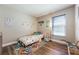 Bedroom features wood floors, window, and dinosaur décor at 1052 Dees Dr, Oviedo, FL 32765
