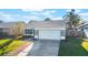 Single-Gathering home featuring an attached two-car garage and manicured lawn at 1052 Dees Dr, Oviedo, FL 32765