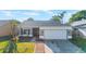 Charming single-story home with a manicured lawn, two-car garage, and neutral gray paint at 1052 Dees Dr, Oviedo, FL 32765