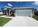 Charming single-story home featuring a two-car garage, red front door, and well-manicured lawn at 13329 Sw 48Th Ave, Ocala, FL 34473