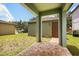 Inviting back porch with a brick paver walkway leading to a brown door with beautiful landscaping around it at 14154 Shocklach Dr, Winter Garden, FL 34787