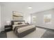 Neutral bedroom with a queen bed, two windows, and an abstract painting above the bed at 14154 Shocklach Dr, Winter Garden, FL 34787