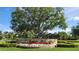 Latham Park community entrance featuring flowerbeds, landscaping and trees at 14154 Shocklach Dr, Winter Garden, FL 34787