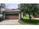 Residential home featuring a two-car garage with a brown door at 14154 Shocklach Dr, Winter Garden, FL 34787