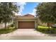 A wide two car garage with a concrete driveway, and grass on either side of the drive at 14154 Shocklach Dr, Winter Garden, FL 34787