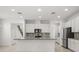 Modern kitchen with stainless steel appliances, gray backsplash, spacious island, and ample white cabinetry at 14154 Shocklach Dr, Winter Garden, FL 34787