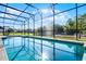Inviting pool with screened-in enclosure, offering serene water views and a private backyard oasis at 2569 Gabrielle Woods Pl, Oviedo, FL 32765