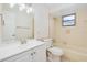 Clean bathroom with updated vanity, shower-tub combo with tile surround and window at 2921 Sabal Palm Dr, Edgewater, FL 32141