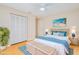 Staged bedroom featuring neutral walls, blue accents, large closet, and wood look tile at 2921 Sabal Palm Dr, Edgewater, FL 32141