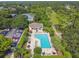 Aerial view of a community pool with lounge chairs and tables surrounded by greenery in a residential neighborhood at 333 La Creek Ct, Debary, FL 32713