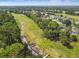 Aerial view of a golf course featuring lush greenery and mature trees within a residential community at 333 La Creek Ct, Debary, FL 32713