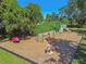 Aerial view of community playground featuring swings, slides, and a rocking horse in a grassy area under a clear, sunny sky at 333 La Creek Ct, Debary, FL 32713