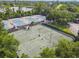 Aerial view of tennis courts near a lake, surrounded by trees in a residential community at 333 La Creek Ct, Debary, FL 32713