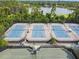 Aerial view of blue and green tennis courts with nets and lighting in a residential community at 333 La Creek Ct, Debary, FL 32713
