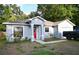 Charming single-story home with a bright red front door and an attached garage at 517 Walnut St, Auburndale, FL 33823