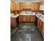 Traditional kitchen featuring oak cabinets and black appliances atop eye-catching multi-toned stone tile flooring at 607 Woodland St, Orlando, FL 32806
