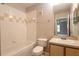 Bright bathroom with a single sink vanity, tile flooring, and a shower-tub combo at 6506 Swissco Dr # 1317, Orlando, FL 32822