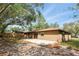 Rear exterior featuring a stucco wall, mature trees and a concrete patio at 100 Des Pinar Ln, Longwood, FL 32750
