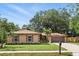 Inviting single-story home featuring a two-car garage, manicured lawn, and mature trees in a suburban neighborhood at 100 Des Pinar Ln, Longwood, FL 32750