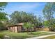 Charming single-story home showcasing manicured lawn and mature shade trees on a sunny day at 100 Des Pinar Ln, Longwood, FL 32750