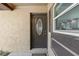 Close-up of a front door featuring an decorative glass window, sidelight and neutral colored exterior at 100 Des Pinar Ln, Longwood, FL 32750