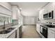 Modern kitchen with stainless appliances, granite countertops, and bright natural light overlooking living area at 100 Des Pinar Ln, Longwood, FL 32750