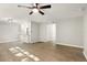 Open-concept living room features neutral paint, modern ceiling fan, wood-look flooring, and access to the kitchen at 100 Des Pinar Ln, Longwood, FL 32750