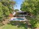 Lush backyard view featuring inviting pool, screened porch, and mature landscaping at 1017 American Beauty St, Orlando, FL 32818